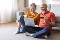 Elderly couple shopping online with credit card and laptop at home Royalty Free Stock Photo
