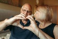 An elderly couple shows a heart with their hands as a sign of love Royalty Free Stock Photo