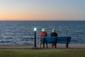 Elderly Couple Sitting On A Bench Fishing