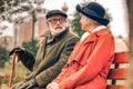 Elderly couple sitting on bench looking at each other Royalty Free Stock Photo