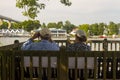 Elderly couple sitting on a bench on a wooden deck