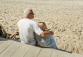 An elderly couple is sitting in a cafe on the terrace, a man hugs a woman