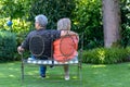 Elderly couple sitting in a lush green garden