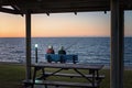 Elderly couple sitting on a park bench fishing