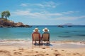 elderly couple sitting on sun lounger chair right on the beach by the sea