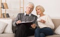 Elderly couple spending time together and reading book Royalty Free Stock Photo