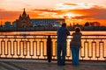 Elderly couple standing back on the river bank and watching the sunset Royalty Free Stock Photo