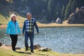 Elderly couple strolling through the breathtaking beauty of nature, maintaining their vitality and serenity, embracing