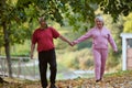 Elderly couple strolling through the breathtaking beauty of nature, maintaining their vitality and serenity, embracing