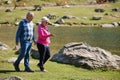 Elderly couple strolling through the breathtaking beauty of nature, maintaining their vitality and serenity, embracing