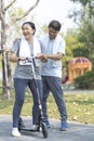 An elderly couple is teaching his wife to play a scooter. Sporty mature couple styaing fit with sport Royalty Free Stock Photo