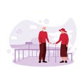 An elderly couple is together on a beach, looking at each other, standing near a guardrail and using a walker. Royalty Free Stock Photo