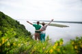 Elderly couple on the top of mountain with hands up.