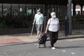 Elderly couple walking across the street wearing face masks