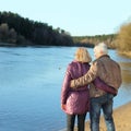 Elderly couple walking hand in hand along the shore. View from the back Royalty Free Stock Photo