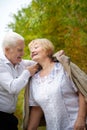 Elderly couple walking in the park on an autumn day Royalty Free Stock Photo