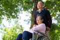 Elderly couples or caregivers take care of the patient in a wheelchair. Concept of a happy retirement with care from a caregiver Royalty Free Stock Photo