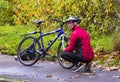 An elderly cyclist hunkers down to make running repairs to his bicycle on the River Lagan towpath in Belfast.