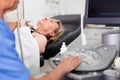 Elderly man sonographer using ultrasonography machine checking female patient in hospital diagnostic room