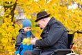 Elderly disabled man playing with his grandson outdoors