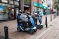 Elderly and disabled people using motorized mobility scooters in high street setting