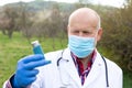 Elderly doctor holding asthma inhaler Royalty Free Stock Photo