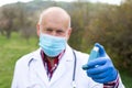 Elderly doctor holding asthma inhaler Royalty Free Stock Photo