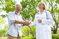 Elderly doctor woman Shake hands patient old man in park