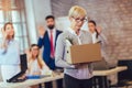 Elderly employee leaving office with box full of belongings. Royalty Free Stock Photo