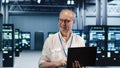Elderly engineer optimizes data center Royalty Free Stock Photo