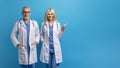 Elderly european doc man and woman posing together on blue