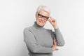 Smiling senior woman with glasses on grey background Royalty Free Stock Photo