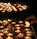 Elderly faithful hand lights a candle