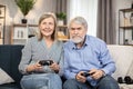 Elderly family posing with gaming joypads in living room