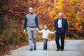 Elderly father adult son and grandson out for a walk in the park Royalty Free Stock Photo