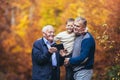 Elderly father adult son and grandson out for a walk in the park, using digital tablet Royalty Free Stock Photo