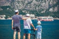 Elderly father adult son and grandson out for a walk at the sea