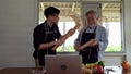 An elderly father and son were dancing in the kitchen, bringing bread to make guitars and singing along with them. Warm family