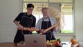 An elderly father and son were dancing in the kitchen, bringing bread to make guitars and singing along with them. Warm family