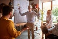 An elderly female boss is arguing with her young male colleague while presenting a business plan at workplace. Business, office,