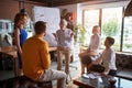 An elderly female boss pissed off on her young male colleague while holding a meeting at workplace. Business, office, job Royalty Free Stock Photo