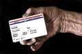 An elderly female hand holds a mock United State government Medicare Health Insurance card. It is a generic card Royalty Free Stock Photo