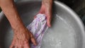 Handwash laundry by wrinkled hands of old woman