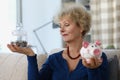 Elderly female hold glass container with saved money for retirement and piggybank