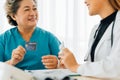 Elderly female patient paying for services with credit card at hospital