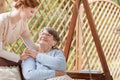 An elderly female pensioner with disabilities sitting on a patio