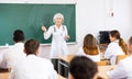 Elderly female professor of medicine giving lecture to students at professional seminar Royalty Free Stock Photo