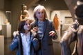 Elderly female tutor showing tween girl ancient sculptures in museum