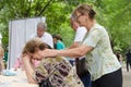 Elderly female volunteer doing relaxing massage to another elderly woman in park