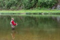 Elderly fisherman in water threw fishing rod. Fly fishing in mountain river Royalty Free Stock Photo